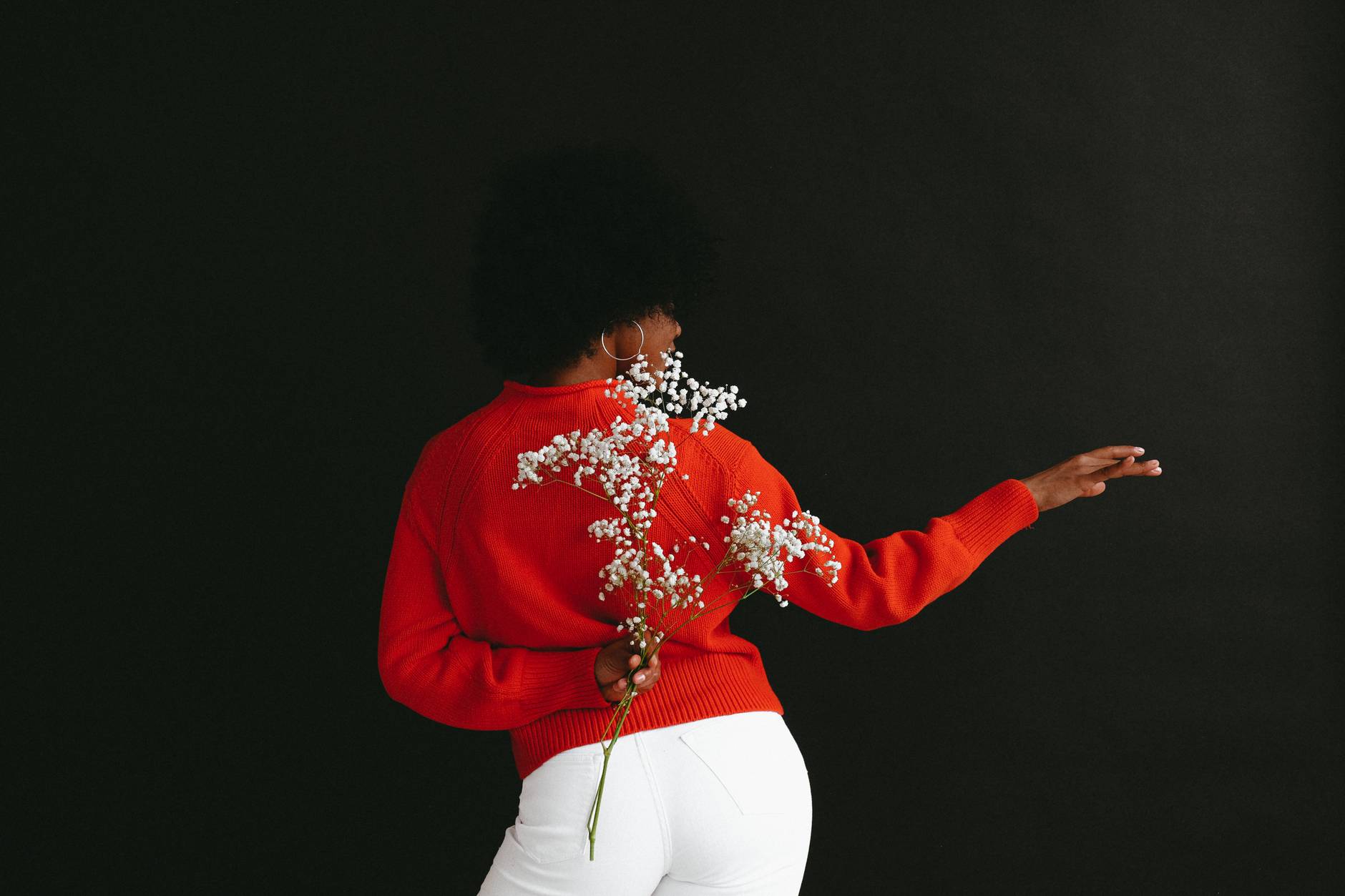 graceful ethnic model with white flower behind back