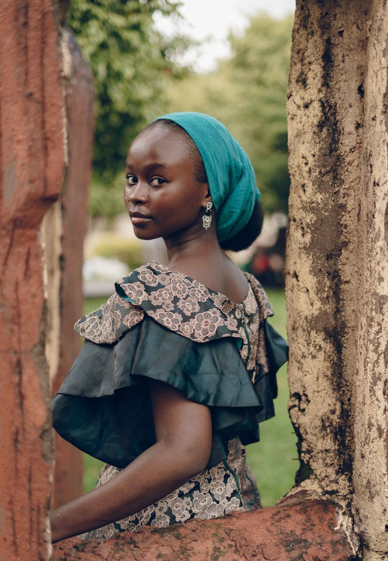 Nigerian woman in vibrant attire posing gracefully outdoors, capturing cultural beauty.