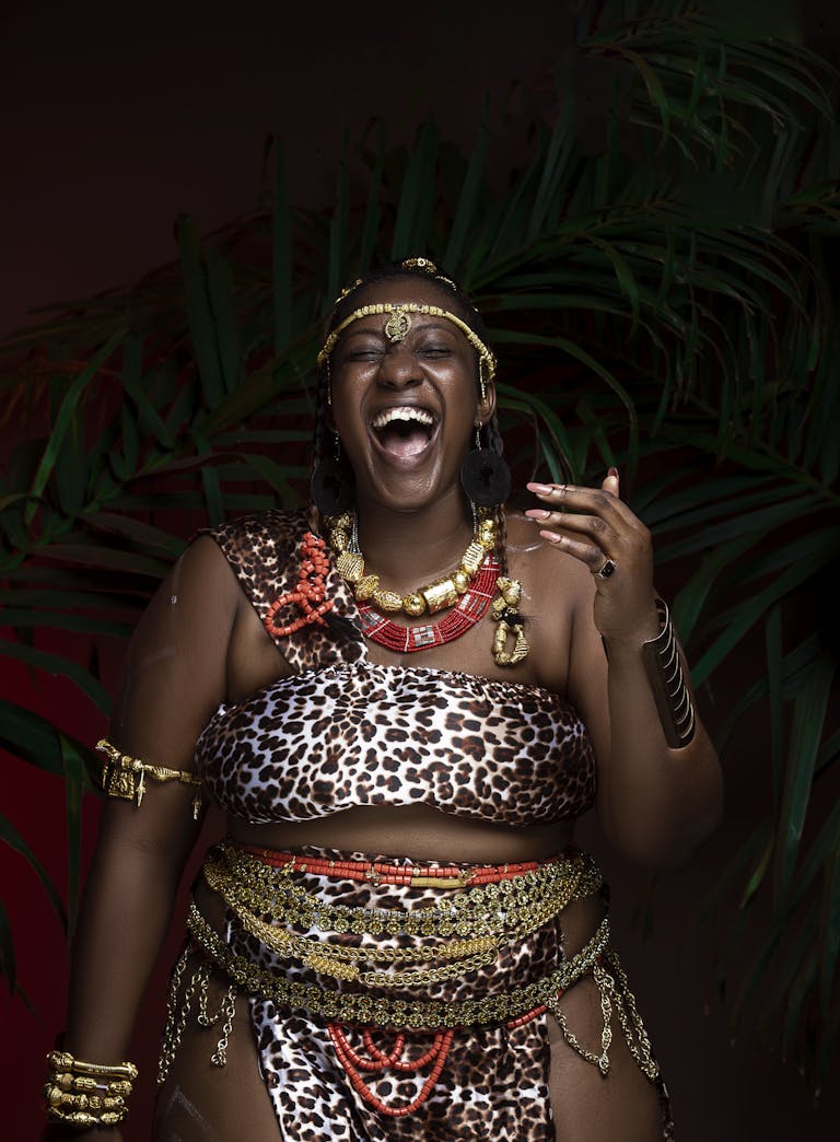 Portrait of an African woman in traditional attire, smiling joyfully.