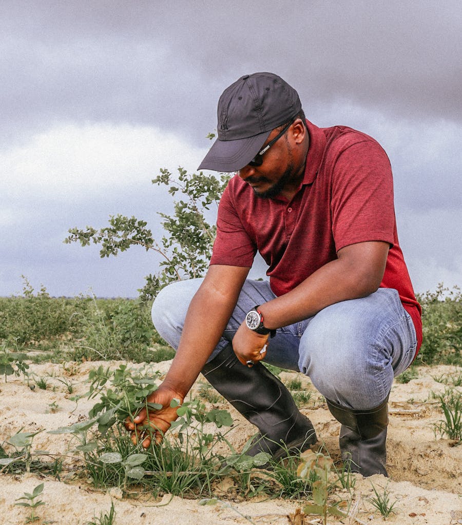 Getting hands in the soil 🌿! This guy vibing with nature, checking out some plants in the sandy terrain. Overcast skies but the green's still popping 😊