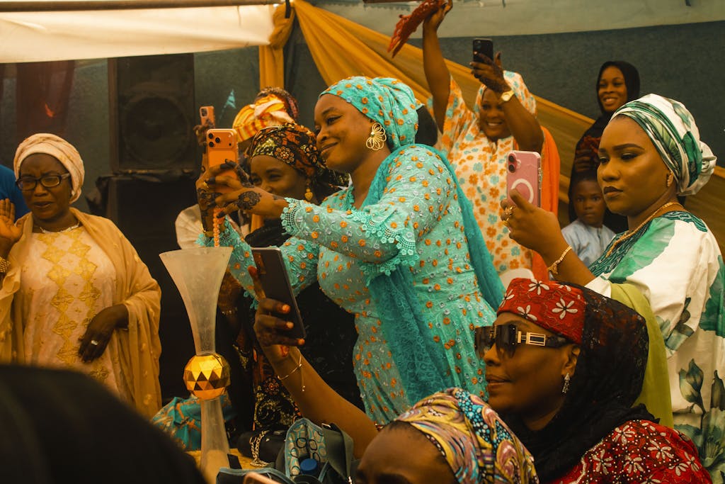 Women in colorful attire capturing moments at a lively celebration.