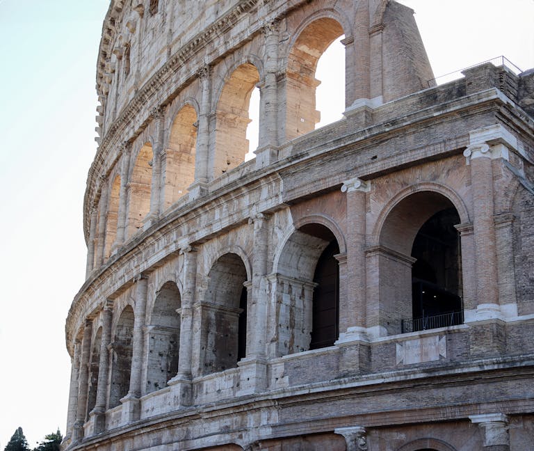 Detailed view of ancient Roman Colosseum arches in Rome, highlighting historical architecture.
