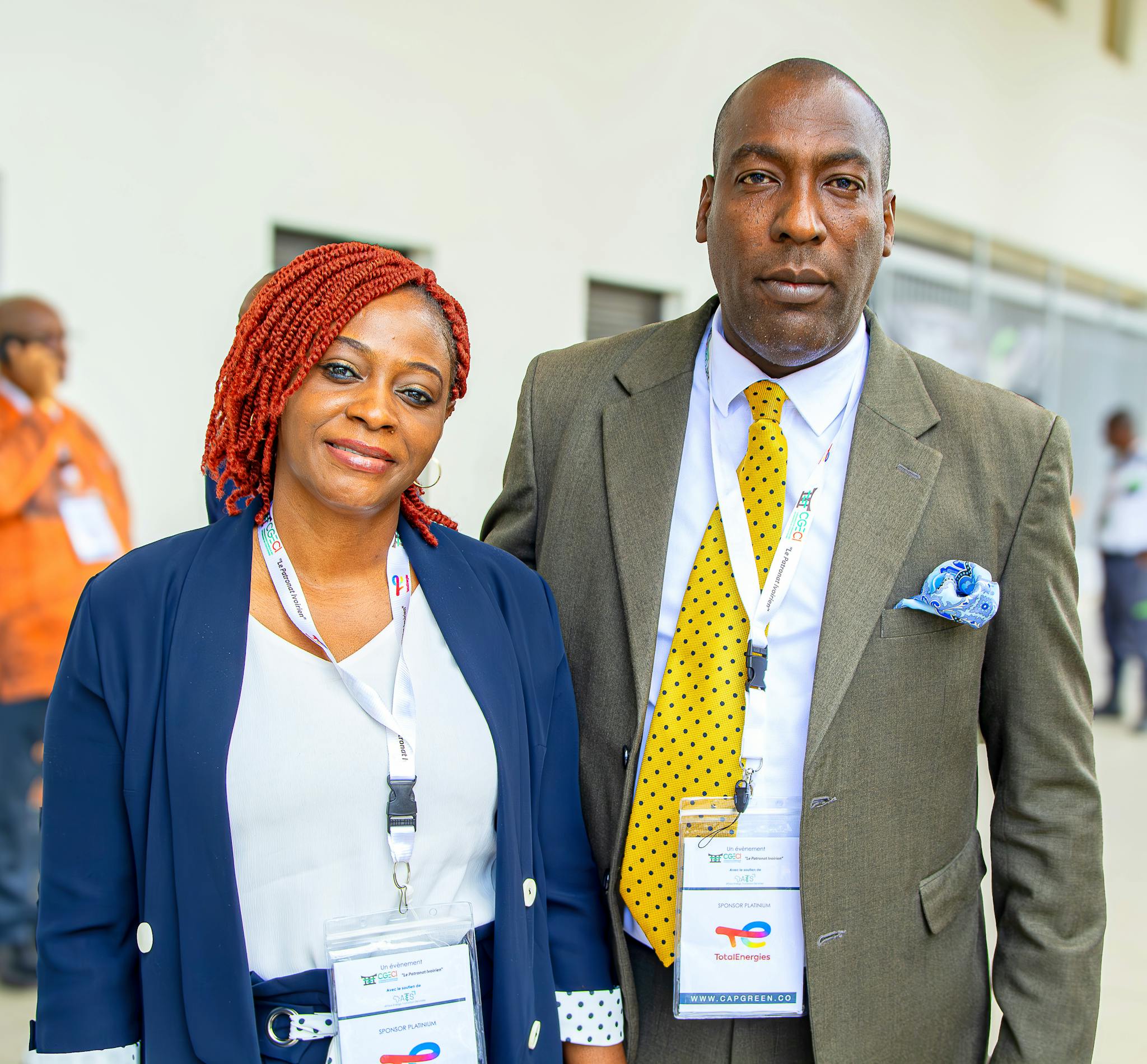 Elegant African couple attending a business conference in professional attire, showcasing cooperation and networking.