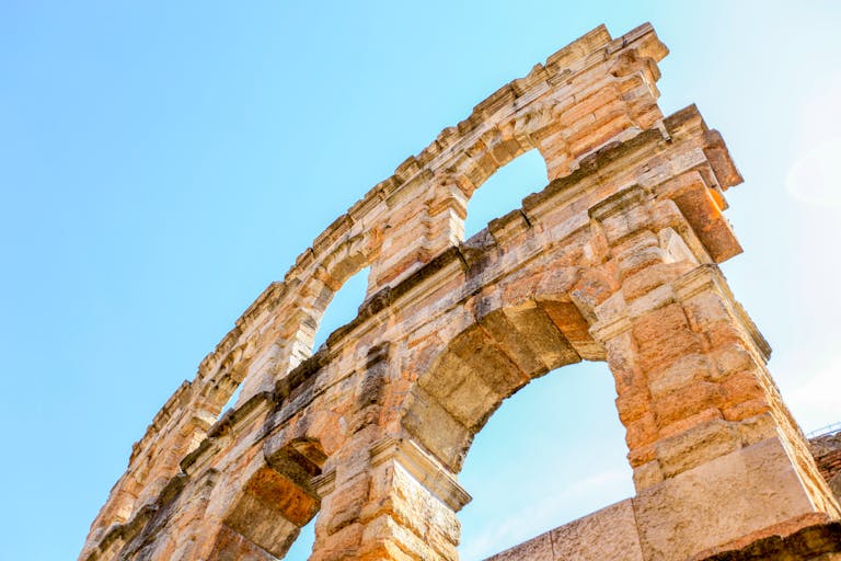 Close-up of the ancient Verona Arena, a Roman amphitheater in Veneto, Italy under a clear blue sky.